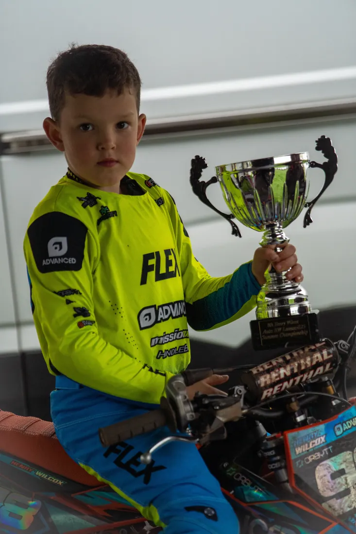 Henry Wilcox holding a winner's cup in his FLEX jersey